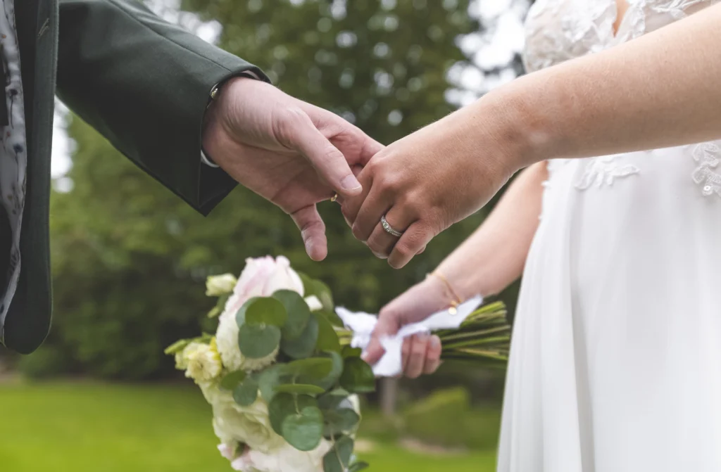 Couple célébrant son union lors d’une cérémonie, entouré de leurs proches dans une atmosphère émouvante.